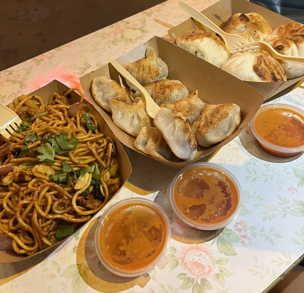 Plates of Taipo Momo, Fried Momo and Chowmein from My Kitchen HK served with spicy red sauce.